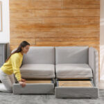 Schlafsofas: Junge Frau klappt das Sofa im Zimmer zu einem Bett auf