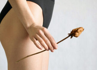 Frau im Slip mit getrockneter Rose in der Hand als Symbol für Scheidentrockenheit