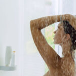 Frau unter der Dusche - Wasserverbrauch reduzieren
