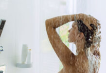 Frau unter der Dusche - Wasserverbrauch reduzieren