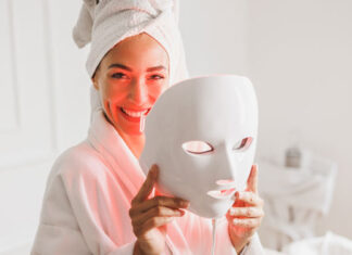 Frau hält eine LED-Maske fürs Gesicht in den Händen