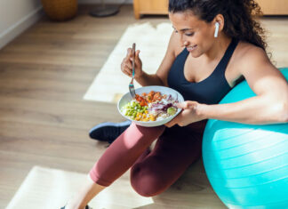 Frau mit Gymnastikball und Bowl pflegt einen gesunden Lebensstil