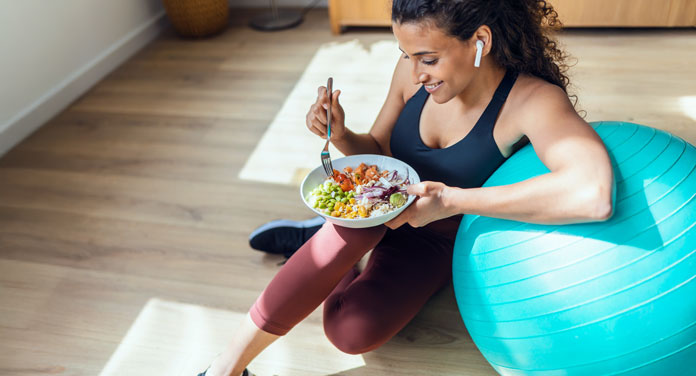 Frau mit Gymnastikball und Bowl pflegt einen gesunden Lebensstil