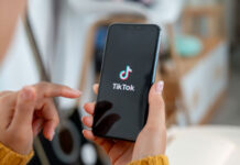 Frau hält Smartphone mit TikTok in der Hand