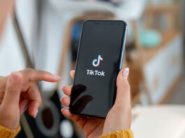 Frau hält Smartphone mit TikTok in der Hand