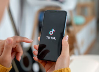 Frau hält Smartphone mit TikTok in der Hand