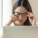 Frau am Laptop hat Schleier vor den Augen