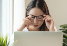 Frau am Laptop hat Schleier vor den Augen