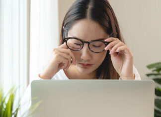 Frau am Laptop hat Schleier vor den Augen
