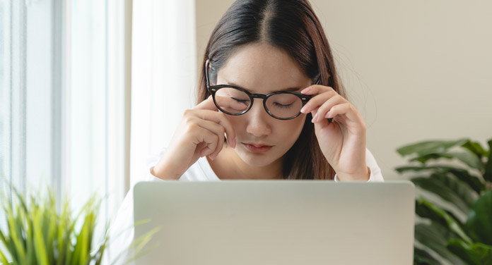 Frau am Laptop hat Schleier vor den Augen