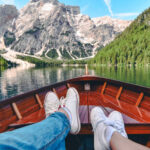 Zwei Personen sitzen im Boot und blicken auf die Bergkulisse, eine typische Szene für den Auftakt eines Reise-Fotobuch