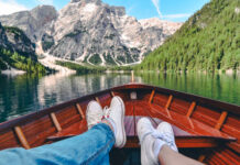 Zwei Personen sitzen im Boot und blicken auf die Bergkulisse, eine typische Szene für den Auftakt eines Reise-Fotobuch