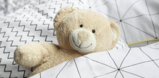 Träume in Samt und Seide: Warum hochwertige Kinderbetten das Herzstück jedes Kinderzimmers sind hochwertige Kinderbetten - Teddy liegt im Bett