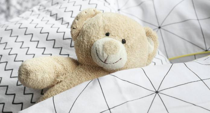 hochwertige Kinderbetten - Teddy liegt im Bett