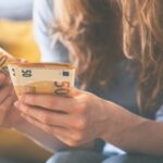 Frau zählt 50-Euro-Scheine. 500 Euro mehr Gehalt im Monat