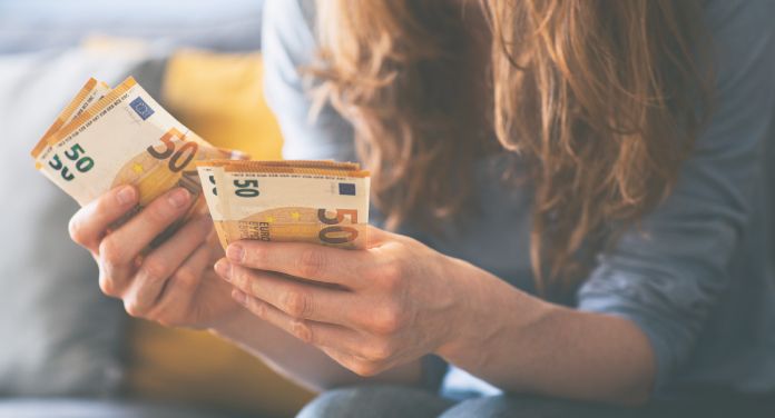 Frau zählt 50-Euro-Scheine. 500 Euro mehr Gehalt im Monat