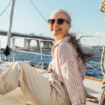 Wie viel Geld brauchst du im Alter wirklich? Frau entspannt auf einem Segelboot - Wie viel Geld brauchst du im Alter wirklich?