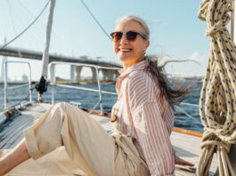 Frau entspannt auf einem Segelboot - Wie viel Geld brauchst du im Alter wirklich?