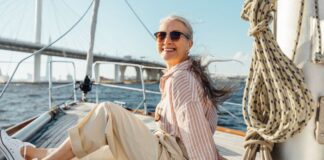 Wie viel Geld brauchst du im Alter wirklich? Frau entspannt auf einem Segelboot - Wie viel Geld brauchst du im Alter wirklich?