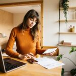 Dein Geld ist nicht nur Zahlenkram – es ist Freiheit. So baust du dir echte finanzielle Sicherheit auf Frau arbeitet am Schreibtisch zu Hause für ihre finanzielle Sicherheit