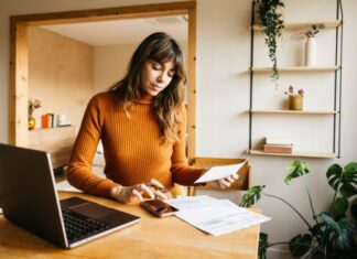 Dein Geld ist nicht nur Zahlenkram – es ist Freiheit. So baust du dir echte finanzielle Sicherheit auf Frau arbeitet am Schreibtisch zu Hause für ihre finanzielle Sicherheit