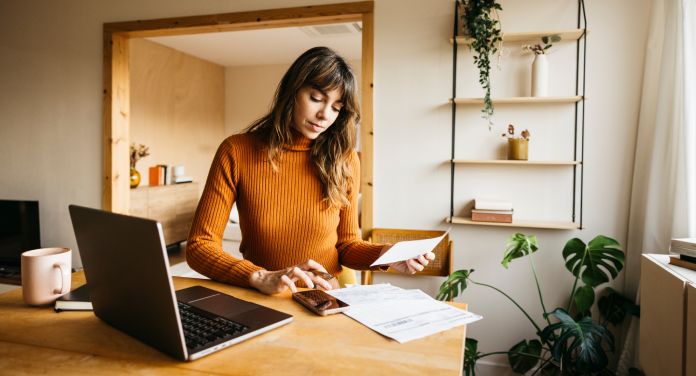 Frau arbeitet am Schreibtisch zu Hause für ihre finanzielle Sicherheit