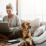 Frau arbeitet am Laptop mit Hund - das Leben neu sortieren