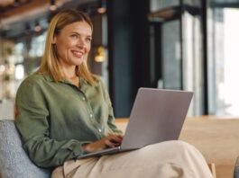 Frau arbeitet lächelnd am Laptop - selbständig machen als Frau