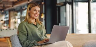 Frau arbeitet lächelnd am Laptop - selbständig machen als Frau