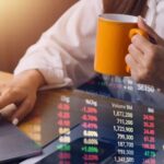Investieren für Anfängerinnen: So startest du mit ETFs und Depot Frau mit Laptop und Kaffeetasse - Investieren für Anfängerinnen