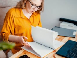 Frau arbeitet am Schreibtisch - Preise kalkulieren für Selbstständige