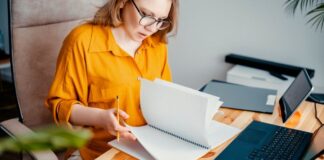 Frau arbeitet am Schreibtisch - Preise kalkulieren für Selbstständige
