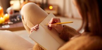 Frau schreibt in ein Notizbuch und fragt sich: was will ich wirklich?