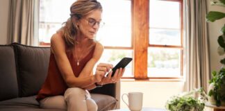 Versicherungen für Frauen: Welche Absicherung wirklich wichtig ist Frau nutzt Smartphone auf der Couch - Versicherungen für Frauen