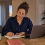 Frau plant nach Feierabend am Laptop ihre beruflichen Möglichkeiten neben dem Job